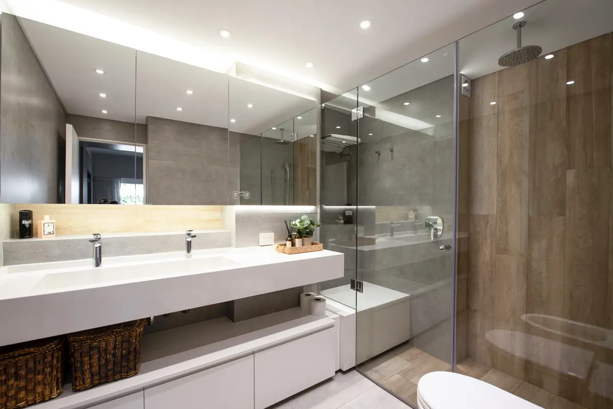 baño moderno con ducha de cristal y pared de madera — proyecto Depto Virrey del Pino, por Ayelen Mayer Arquitectura, en Buenos Aires